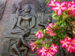 THAILAND: Gorgeous stone Buddha in Sukothai Historical Park, framed by pretty pink flowers.